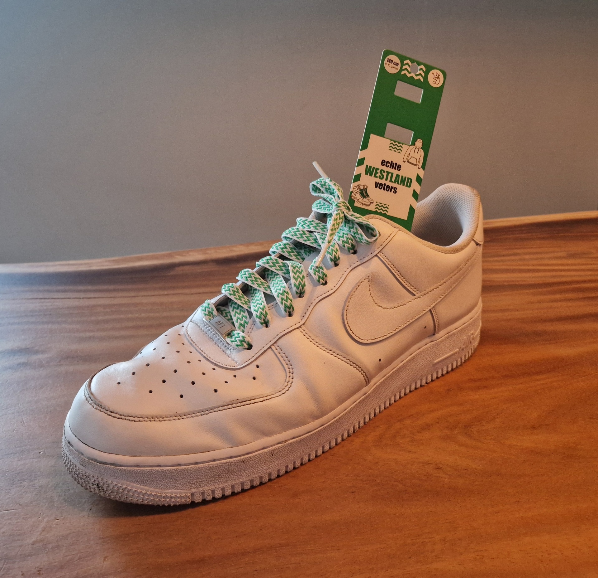 Witte sneaker geregen met de groen-witte Westlandse veter, met de verpakking in de schoen